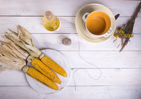 Baked grilled cobs of corn on white wooden background. Top view.の写真素材