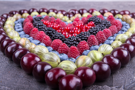 Rows of assorted fruits and berries: sweet cherry, bluberries, raspberries, red and black currant, blackberries. Helthy eating food concept. Top view.の写真素材