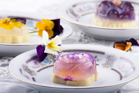 Unique japanese dessert Havaro of jelly and bavarian cream with edible violet flowers. Gelatin healthy eating dessert. Top view.の写真素材