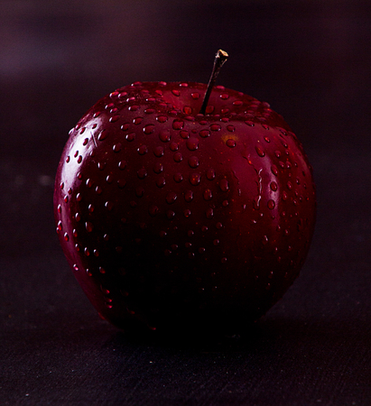 Red apple with water drops on black background. Dark style.の写真素材