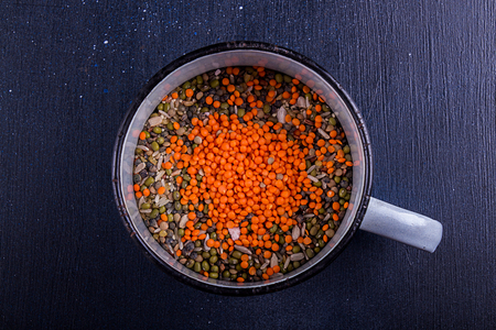Food background. Big cup of various Legumes, sereals, beans, grain and seeds. Kind of lentils, bulgur, mash, chickpeas, sunflower seeds, couscous, rice.の写真素材