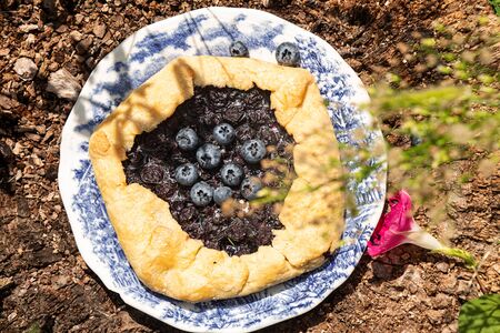Summer sweet pie cake galette with  blueberry on rustic background outside. Top viewの写真素材