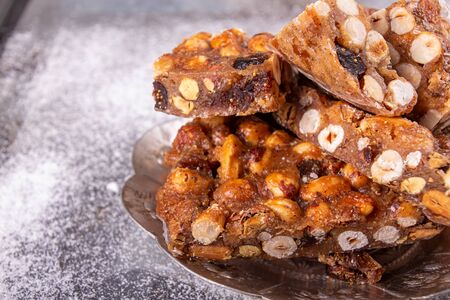 Italian sweet nuts, hazelnuts, almonds, figs, honey dessert over on sugar powder surfase.の写真素材