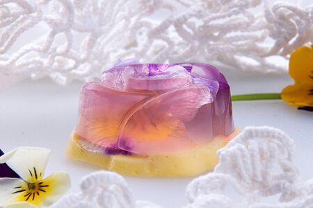 Unique japanese dessert Havaro of jelly and bavarian cream with edible violet flowers. Gelatin...