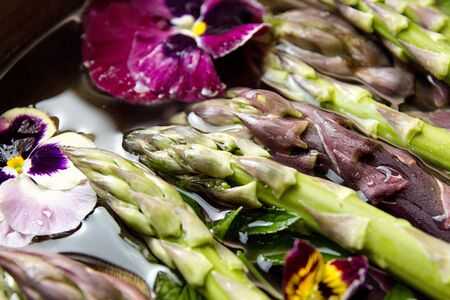 Set of raw white, green, purple asparagus in copper basin with violet and mint. Old wooden rustic background. Organic healthy eating concept. Close up. Overhead.の写真素材