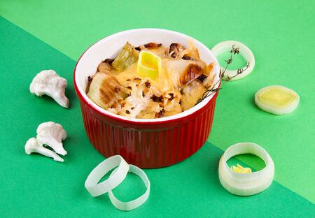 Cauliflower gratin with leek, chicken breast and cheese over on green backgroundの写真素材