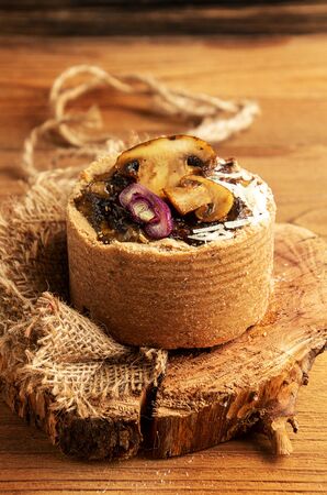 Tarts with mushrooms, caramelized red onion and cheese over on old wooden rustic background.の写真素材