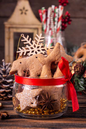Gingerbread cookies on glass jar, Christmas and New Year ornament on old wooden background. Overhead of Christmas New Year holiday background. Copy spaceの写真素材