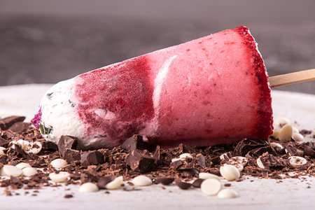 Strawberry ice cream lolly pops with whipped cream decorated chocolate on white wooden background. Close upの写真素材