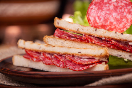 Heep of sandwiches toasted bread tsscher salami on wooden table. fast food unhealthy concept.の写真素材