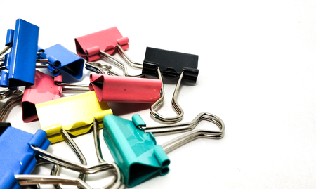 Multicolored paper clips in a pile closeup on a white backgroundの写真素材