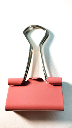 One pink paper clip closeup on white backgroundの写真素材