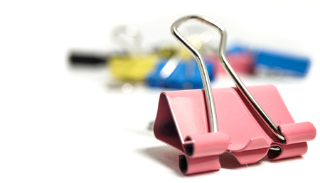 Multicolored paper clips in a pile closeup on a white backgroundの写真素材