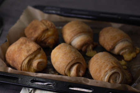 Homemade pastry puff buns with cheese on a baking sheet close-upの写真素材