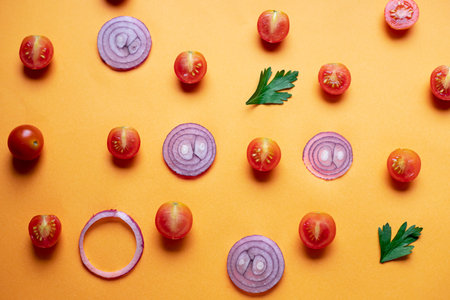 Tomatoes cherry and red onions on an orange backgroundの写真素材