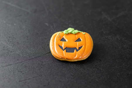 Bright Halloween gingerbread cookies on a black background. Orange pumpkin cookie.の写真素材