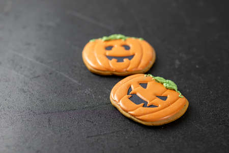 Bright Halloween gingerbread cookies on a black background. Orange pumpkins cookies.の写真素材