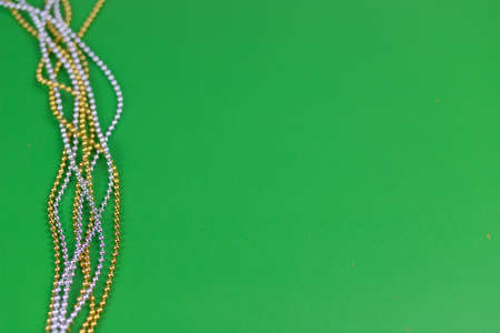 Christmas composition of gold and silver beads on a green background.の写真素材
