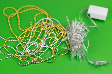 Christmas composition of gold and silver beads on a green background.の写真素材