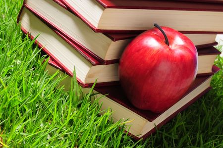 Books and apple on grass.の写真素材