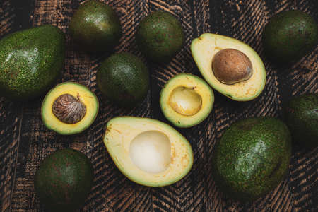 Avocados whole on  wooden  table background with copyspaceの写真素材