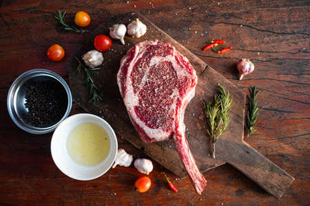 Sliced grilled thai steak served on white plate with grilled sliced lemon, tomatoes, garlicの写真素材