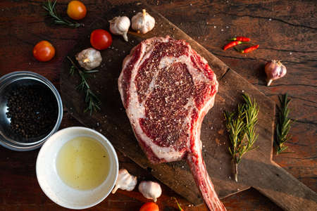Sliced grilled thai steak served on white plate with grilled sliced lemon, tomatoes, garlicの写真素材