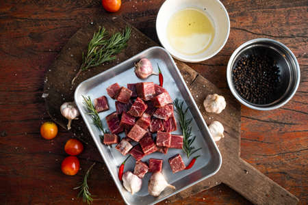 Sliced grilled thai steak served on white plate with grilled sliced lemon, tomatoes, garlicの写真素材