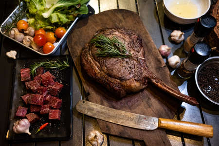 Sliced grilled thai steak served on white plate with grilled sliced lemon, tomatoes, garlicの写真素材