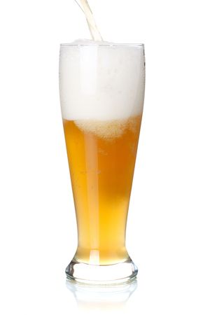 Beer collection - White beer is pouring into a glass from bottleの写真素材