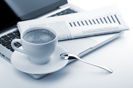 Cappuccino cup with laptop and newspaper. Blue tonedの写真素材
