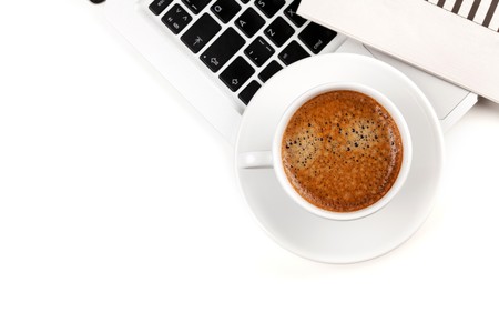 Cappuccino cup on laptop. Above view. Isolated on white backgroundの写真素材