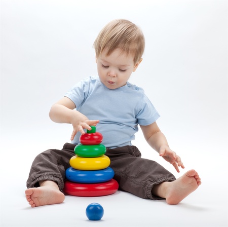 Small baby with a toy pyramid. Isolated on white backgroundの写真素材