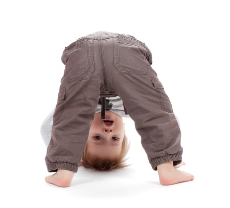 Small baby stands on head. Isolated on white backgroundの写真素材