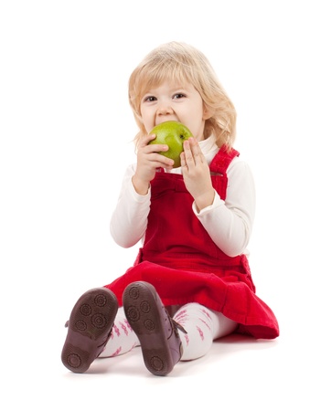 Baby girl eating apple. Isolated on white backgroundの写真素材