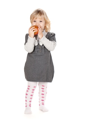 Baby girl eating apple. Isolated on white backgroundの写真素材