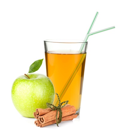 Apple juice in a glass, green apple and cinnamon sticks. Isolated on white backgroundの写真素材