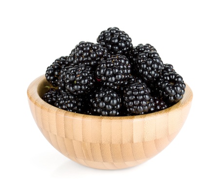 Blackberry in wooden bowl  Isolated on white backgroundの写真素材