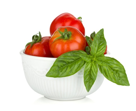 Ripe tomatoes and basil. Isolated on white backgroundの写真素材