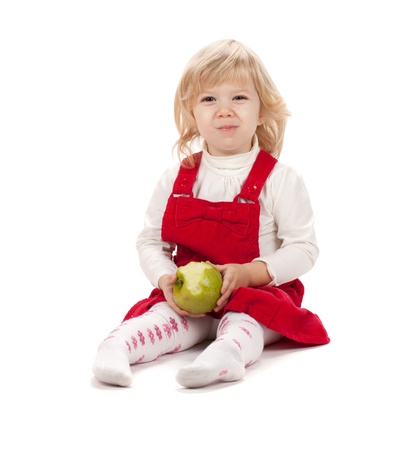 Baby girl eating apple. Isolated on white backgroundの写真素材