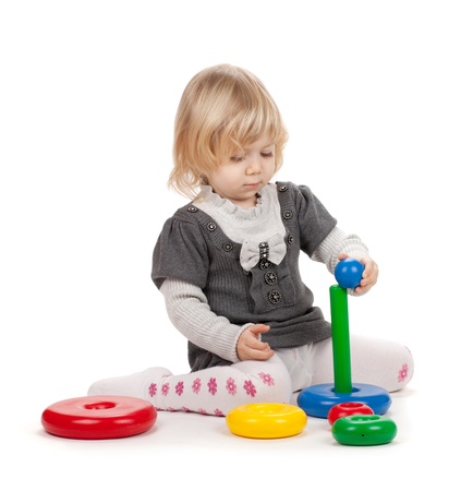 Baby girl with a toy pyramid. Isolated on white backgroundの写真素材