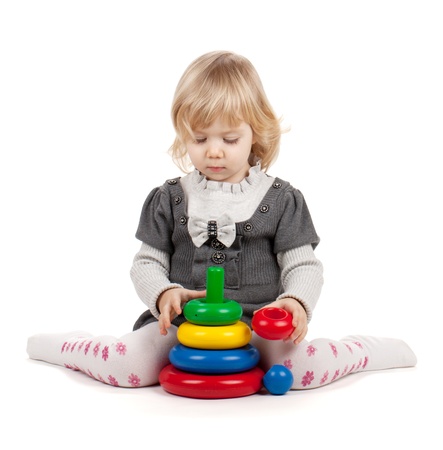 Baby girl with a toy pyramid. Isolated on white backgroundの写真素材