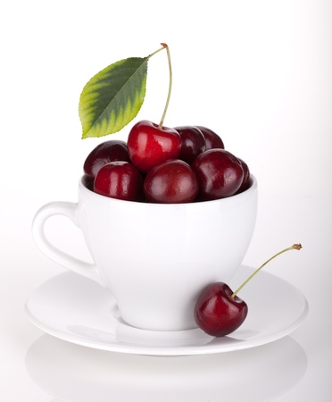 Ripe cherries in a coffee cup  On whiteの写真素材