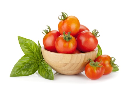 Ripe tomatoes in a bowl and basil. Isolated on white backgroundの写真素材