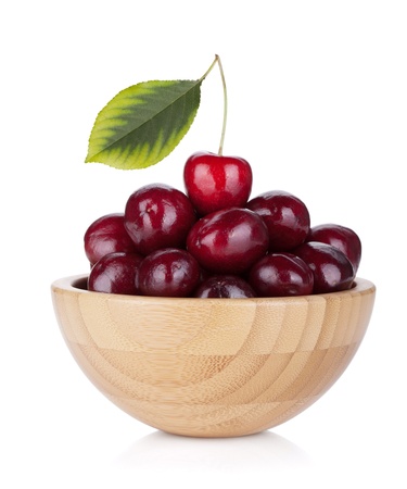 Ripe cherries in a wooden bowl. Isolated on white backgroundの写真素材