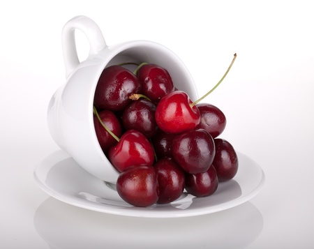 Ripe cherries in a coffee cup  On whiteの写真素材