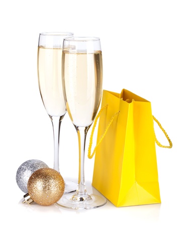 Champagne glasses, christmas baubles and gift bag. Isolated on white backgroundの写真素材