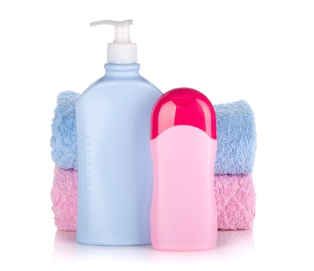 Shampoo and gel bottles with towels. Isolated on white backgroundの写真素材