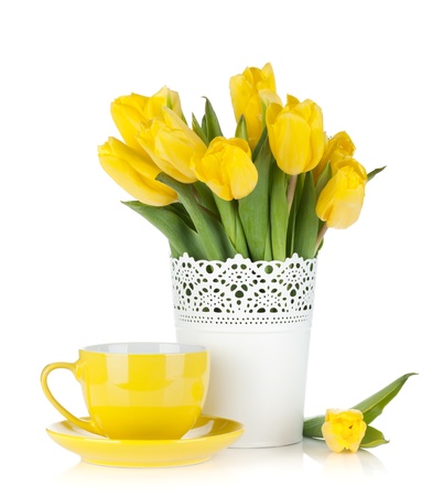 Yellow tulips and tea cup. Isolated on white background