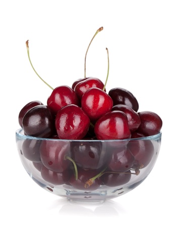 Ripe cherries in a glass bowl. Isolated on white backgroundの写真素材